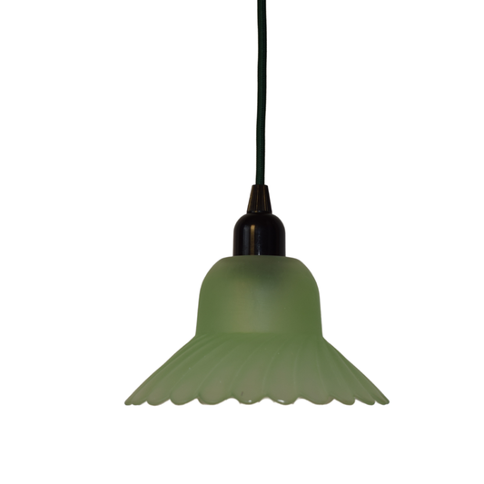 En retro pendellampe med en matgrøn tulipanformet glasskærm med rillede detaljer, monteret på en sort fatning og hængende fra en sort ledning.