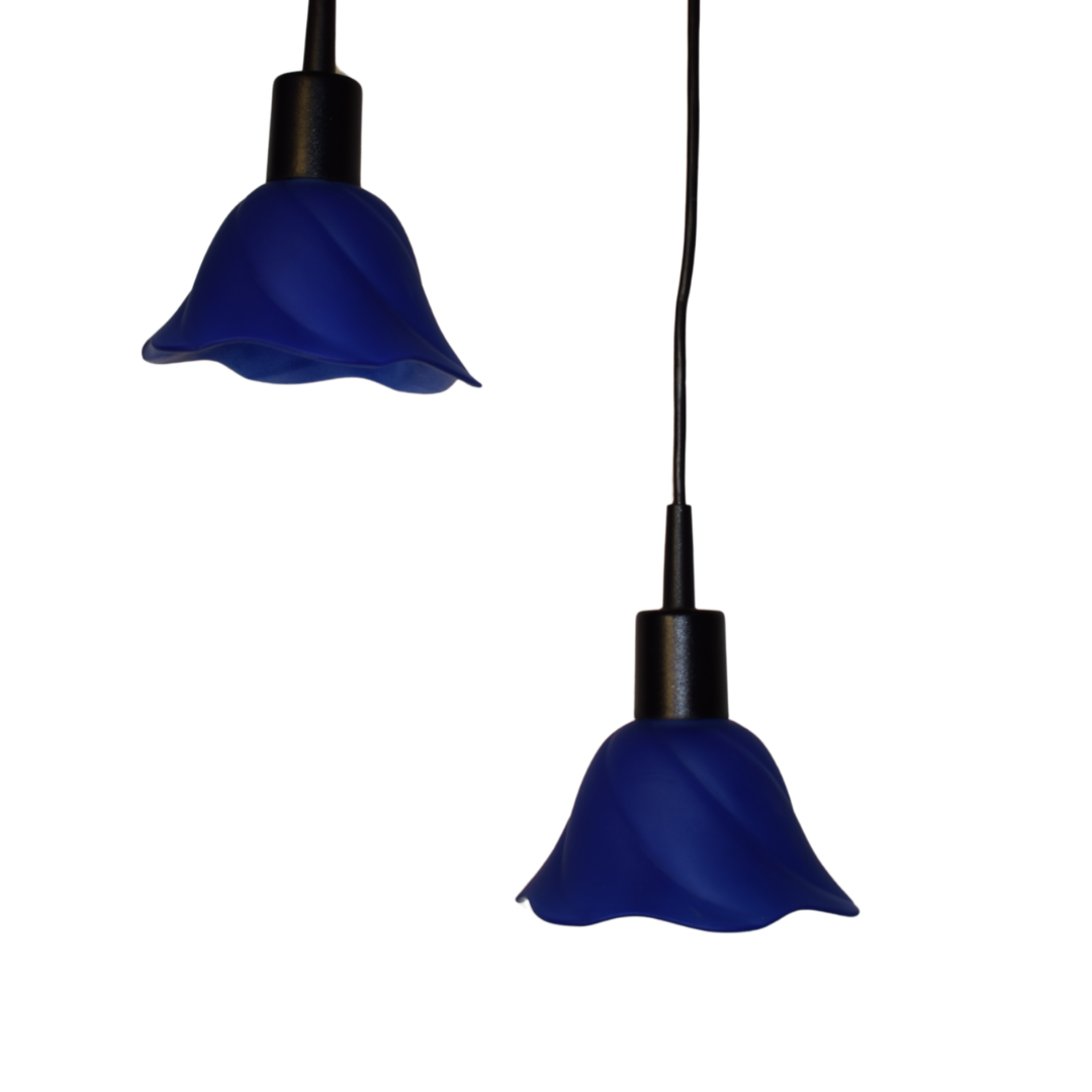 To retro pendellamper med tulipanformede blå glasskærme og sorte fatninger.